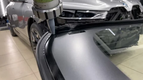 Automobile special workers replacing windshield of a car in auto service. Stock Footage 281716275