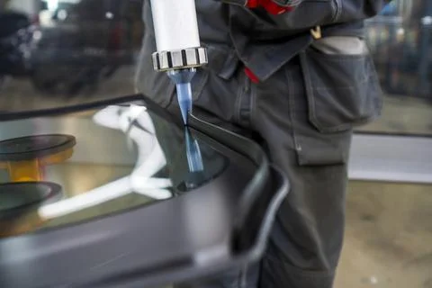 Automobile special workers replacing windshield of a car. Stock Photos