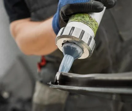 Automobile special workers replacing windshield of a car in auto service st.. Stock Photos