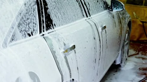 Automobile stands in soap foam inside carwash garage Stock Footage 11046125