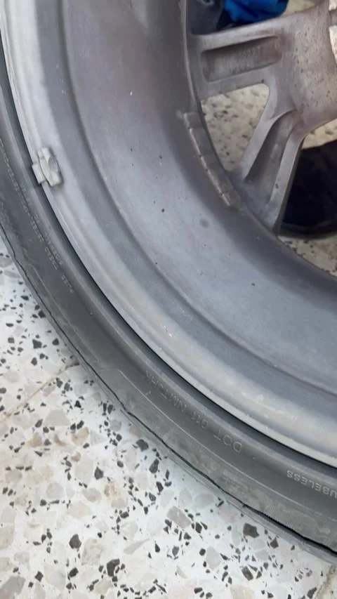 Automobile technician evaluates worn tire for potential safety hazards and Stock Footage 324807450