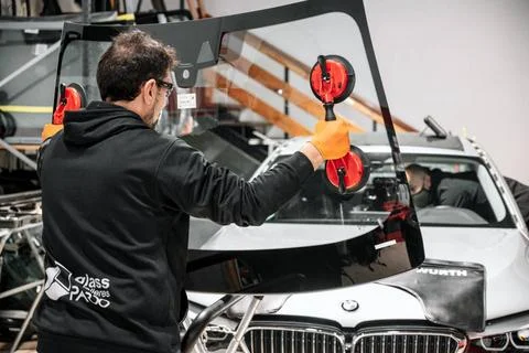 Automobile technician worker replacing windscreen or windshield of a car i... Stock Photos