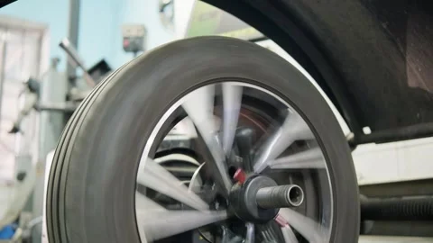 Automobile tire spinning on a balancing machine in a car service station Stock Footage 339273791