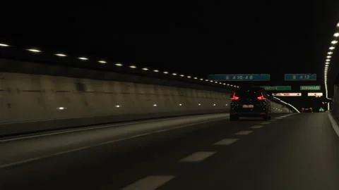 Automobiles drive through an underground highway traffic tunnel in France Stock Footage 337243191