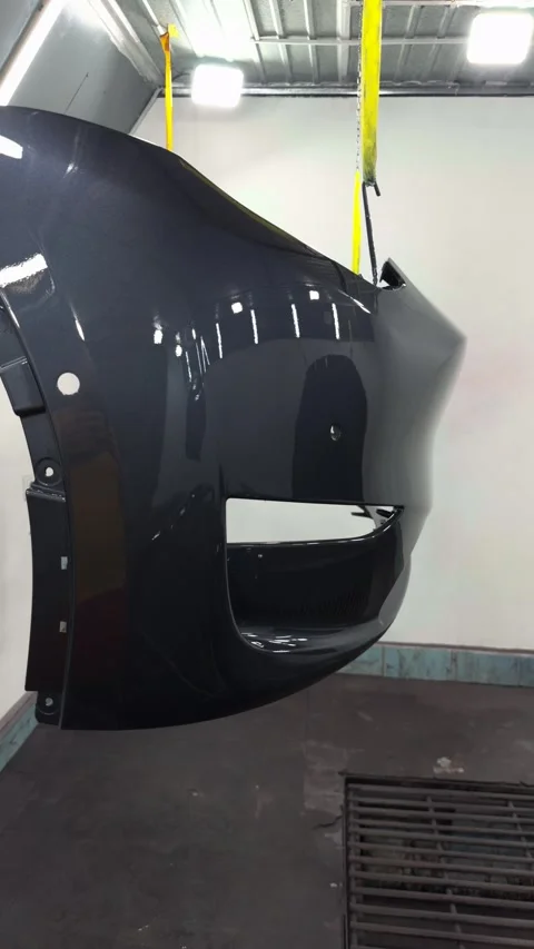 Automotive bumper undergoing a high-quality paint finishing process in a clean w Stock Footage 341134607