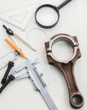 Automotive engineering working table with engine piston and drawing tool Stock Photos