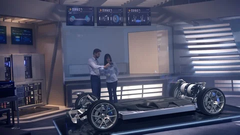 Automotive engineers analyzing design of Electric Car Stock Footage 119710053