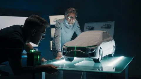Automotive engineers discuss the design of prototype car model using green laser Stock Photos