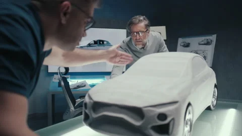 Automotive engineers work in a studio discuss design of prototype car sculpture Stock Footage 219449291