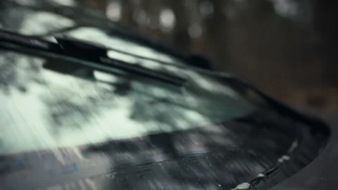 Automotive front windshield wipers on a vehicle swiftly move clearing dirt a Stock Footage 331315757