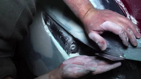 Automotive mechanic painter sanding the surface of the car for priming the surfa Stock Footage 227537701