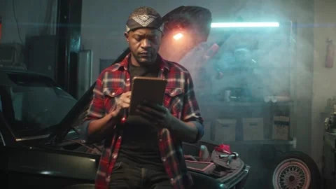 Automotive mechanic running diagnostics software on tablet. African american Video stock 277430423