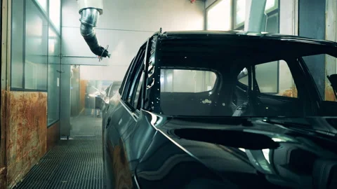 Automotive painter robots painting a car at a production line Stock Footage