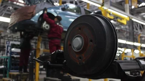 Automotive part on the conveyor, the worker does the work. Stock Footage 122335855
