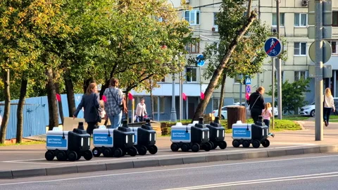 Autonomous Courier Robot Fleet for Local Delivery Beside Busy City Sidewalk Stock Footage 345638592
