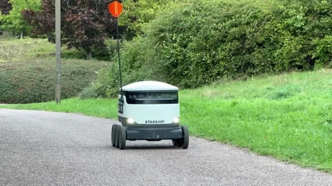 Autonomous delivery robot on footpath, Milton Keynes, England Stock Footage 319573932