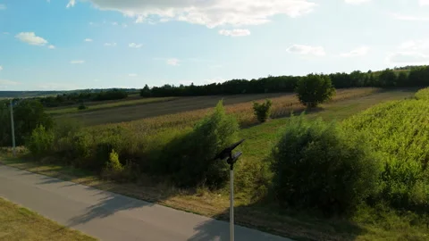 Autonomous lighting fixture illuminates expansive green field, showcasing solar Stock Footage 318718461