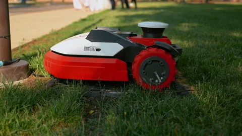 Autonomous robotic lawn mower trimming grass along the edge of a residential Video stock 340384034