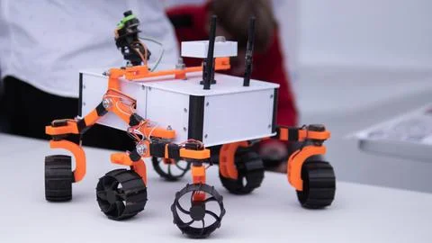 Autonomous wheeled robot prototype with orange suspension, white chassis Foto stock