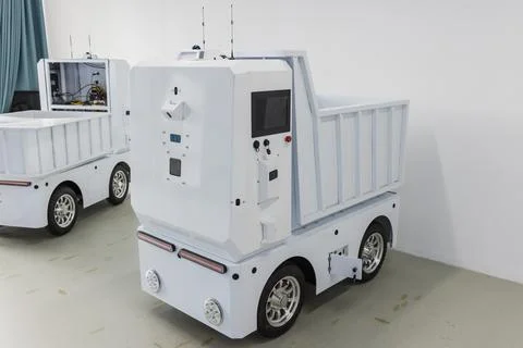 Autonomous white delivery robot dumper parked in white room Stock Photos
