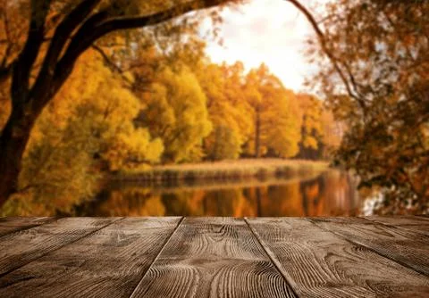 Autumn background, close up of old empty wooden table over the lake Stock Photos