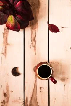 Autumn background. Cup of coffee on the table with leaves Stock Photos