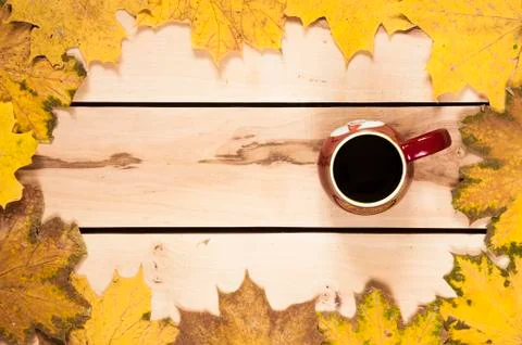 Autumn background. Cup of coffee on the table with leaves Stock Photos