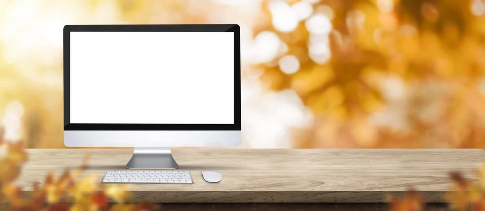 Autumn background.Blank desktop computer on rustic wood table with blur fores Foto stock