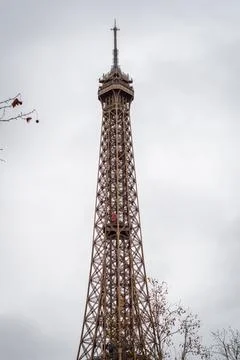 Autumn branches on the Eiffel Tower in Paris with its rising red elevator Stock Photos