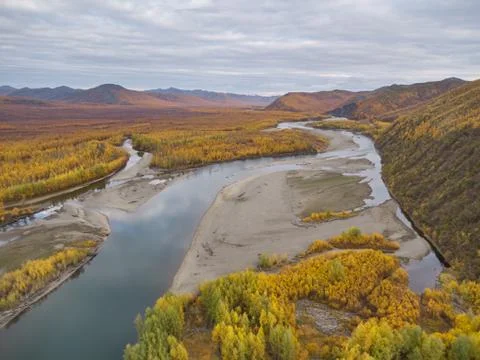 Autumn. The clouds are reflected in the river surrounded by mountains. Kolyma Photos