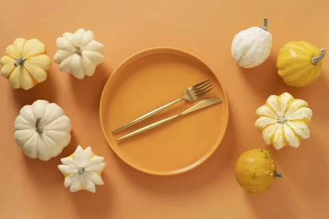 Autumn composition of colorful different small pumpkins, orange empty plate with Stock Photos