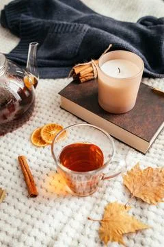 Autumn composition. A cup of hot tea, a candle, a book, a knitted sweater and a Stock Photos