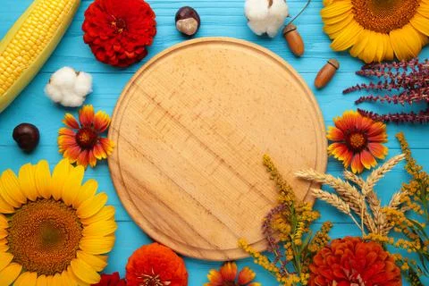 Autumn composition. Frame made of fresh flowers on blue wooden background. Fl Stock Photos