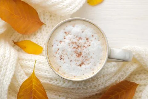 Autumn composition with hot coffee, a warm scarf and yellow leaves on a white Stock Photos