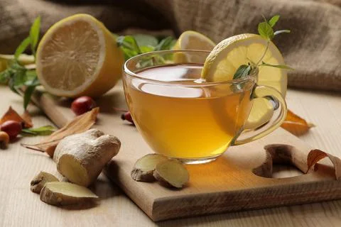 Autumn composition with hot tea with ginger and lemon on a natural wooden tab Stock Photos