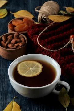 Autumn composition with hot tea nuts berries and autumn yellow leaves on a da Stock Photos