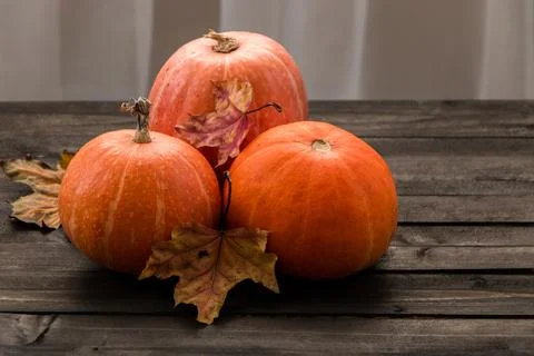 Autumn composition of pumpkins and maple leaves on a wooden table Stock-Fotos