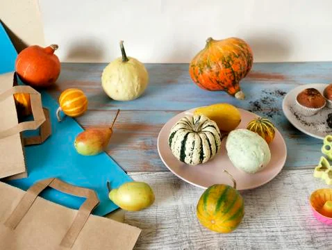 Autumn composition of pumpkins of different varieties, cupcakes, pears Stock Photos