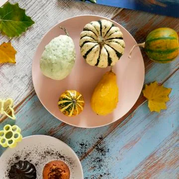 Autumn composition of pumpkins of different varieties, cupcakes, pears Stock Photos