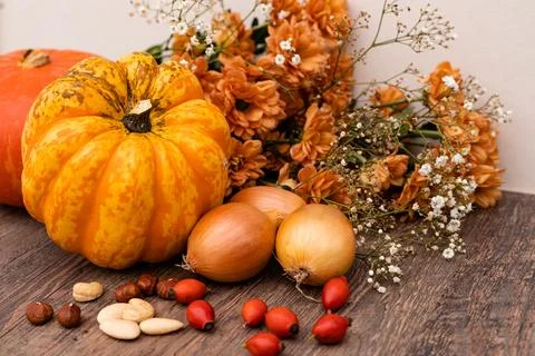 Autumn composition. On the table are pumpkins, onions, nuts, rose hips. Cooking Stock Photos