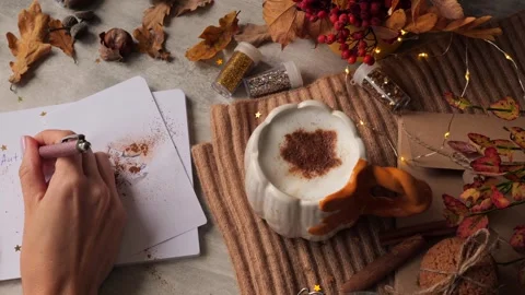 Autumn composition on table with cup of hot latte with cinnamon leaf pattern Stock Footage 250792517