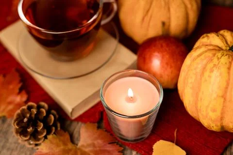 Autumn composition, tea, pumpkins, candle on the table. Autumn comfort at hom Stock Photos