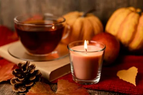 Autumn composition, tea, pumpkins, candle on the table. Autumn comfort at hom Stock Photos