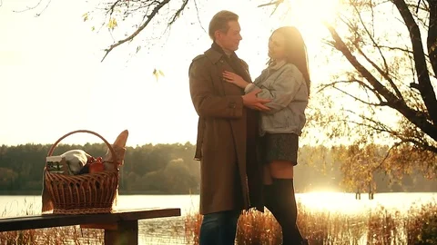Autumn couple. Beautiful couple in warm clothes standing near the lake, where re Stock Footage