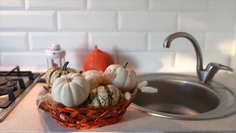 Autumn cozy mood composition. Pumpkins in the basket on kitchen table Stock Footage 238076376