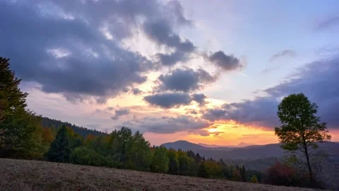 Autumn deciduous forest, meadow in foreground, Dramatic clouds at sunset 動画素材 221638192