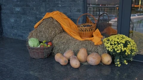 Autumn decor with straw bale, pumpkins, flowers and a basket with vegetables. Stock Footage 141515693