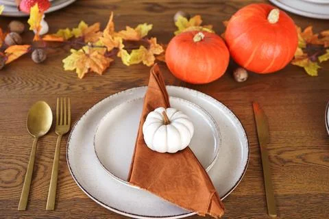 Autumn dinner setting with pumpkins, fall leaves, and elegant tableware for.. Stock Photos