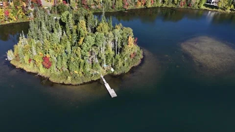 Autumn drone descent toward a small island and dock Stock Footage 346555624
