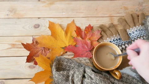 Autumn fall leaves, hot steaming cup of morning coffee and a warm scarf on wo Stock Footage 142389751